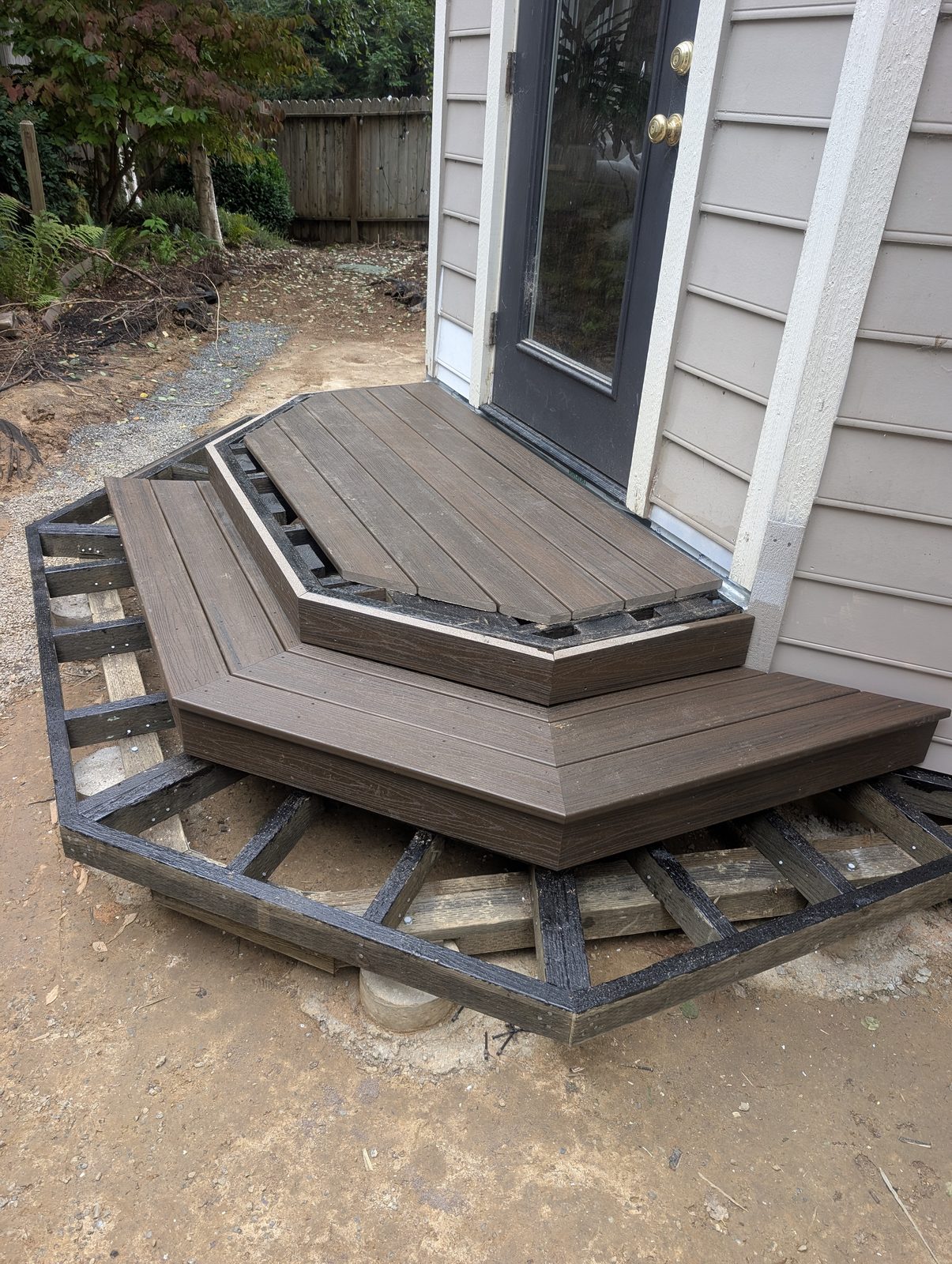 Multi-tier composite deck nearly complete with finished surface boards and stairs by NorCal Exterior