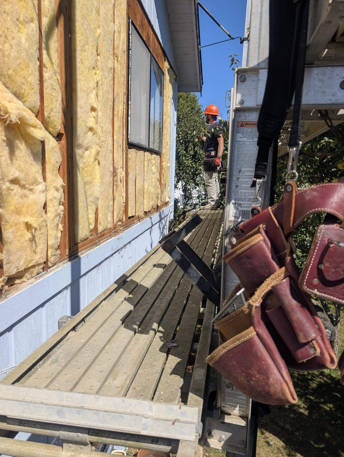 Wall opened up showing fresh insulation around a window opening during a NorCal Exterior project